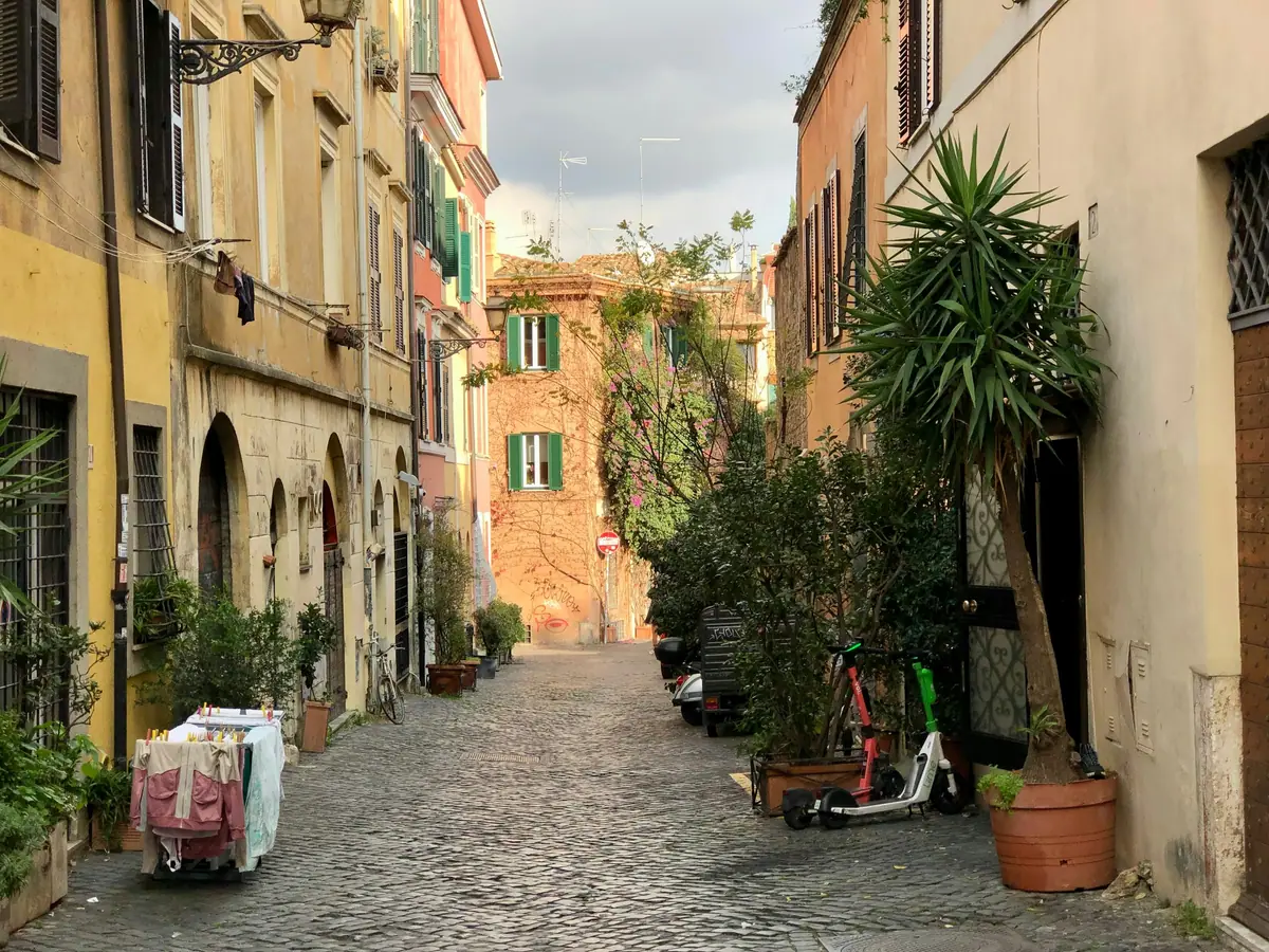 Vicolo di Trastevere con edifici color ocra e piante